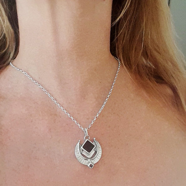 Silver necklace with a pendant on a person's neck