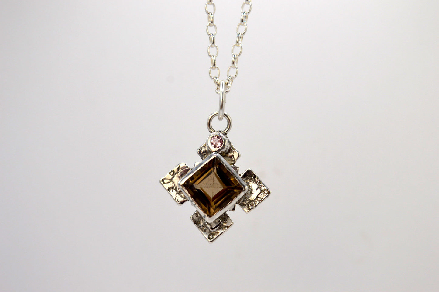 Necklace with a pendant featuring a brown gemstone on a white background