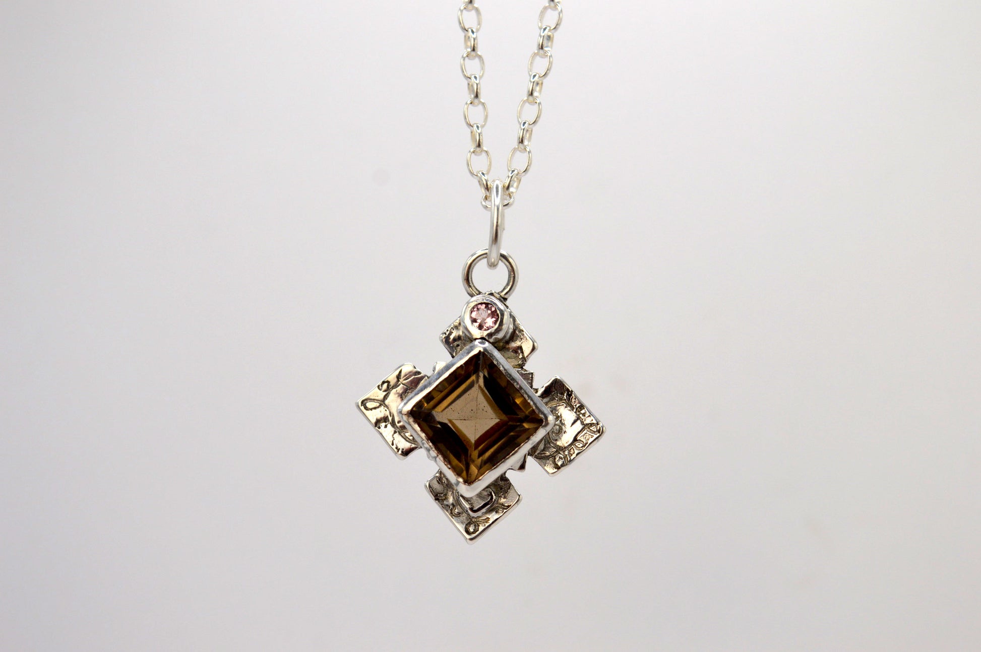 Necklace with a pendant featuring a brown gemstone on a white background