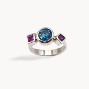 Silver ring with a blue gemstone on a white background