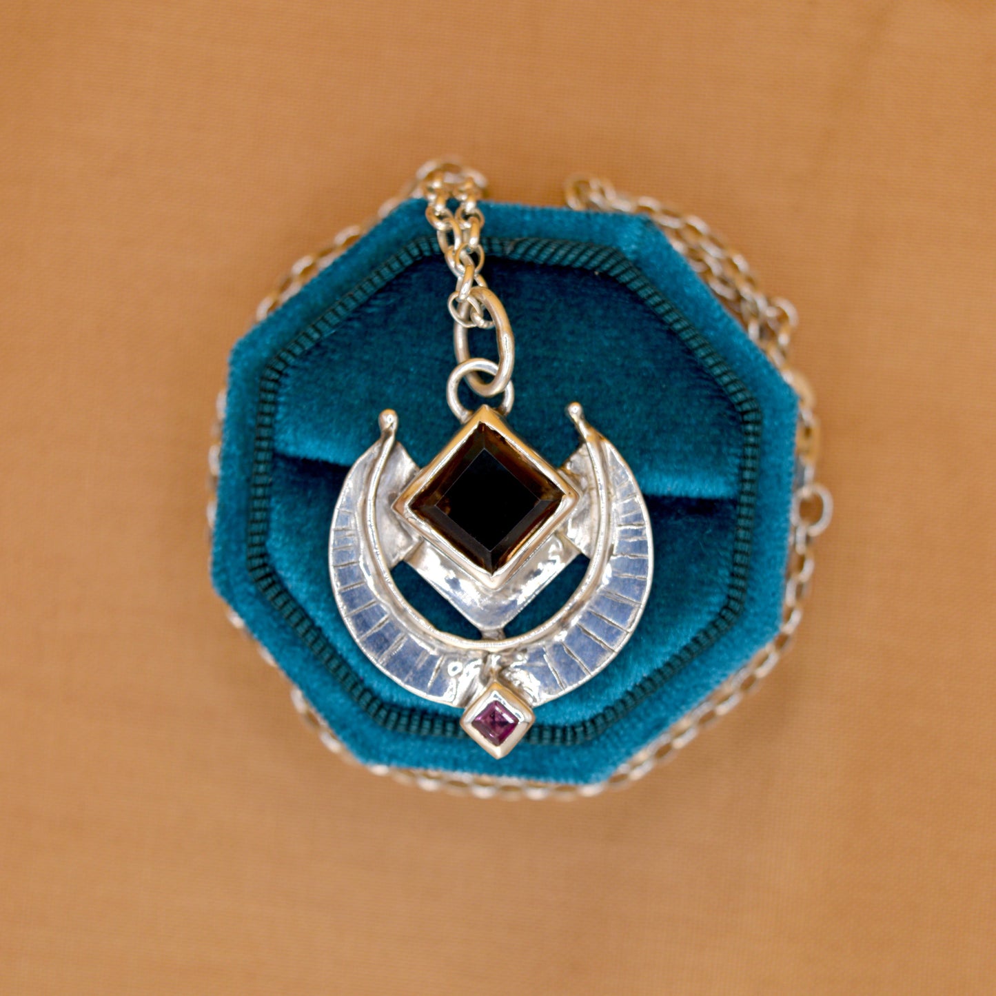 Necklace with blue pendant on a brown background