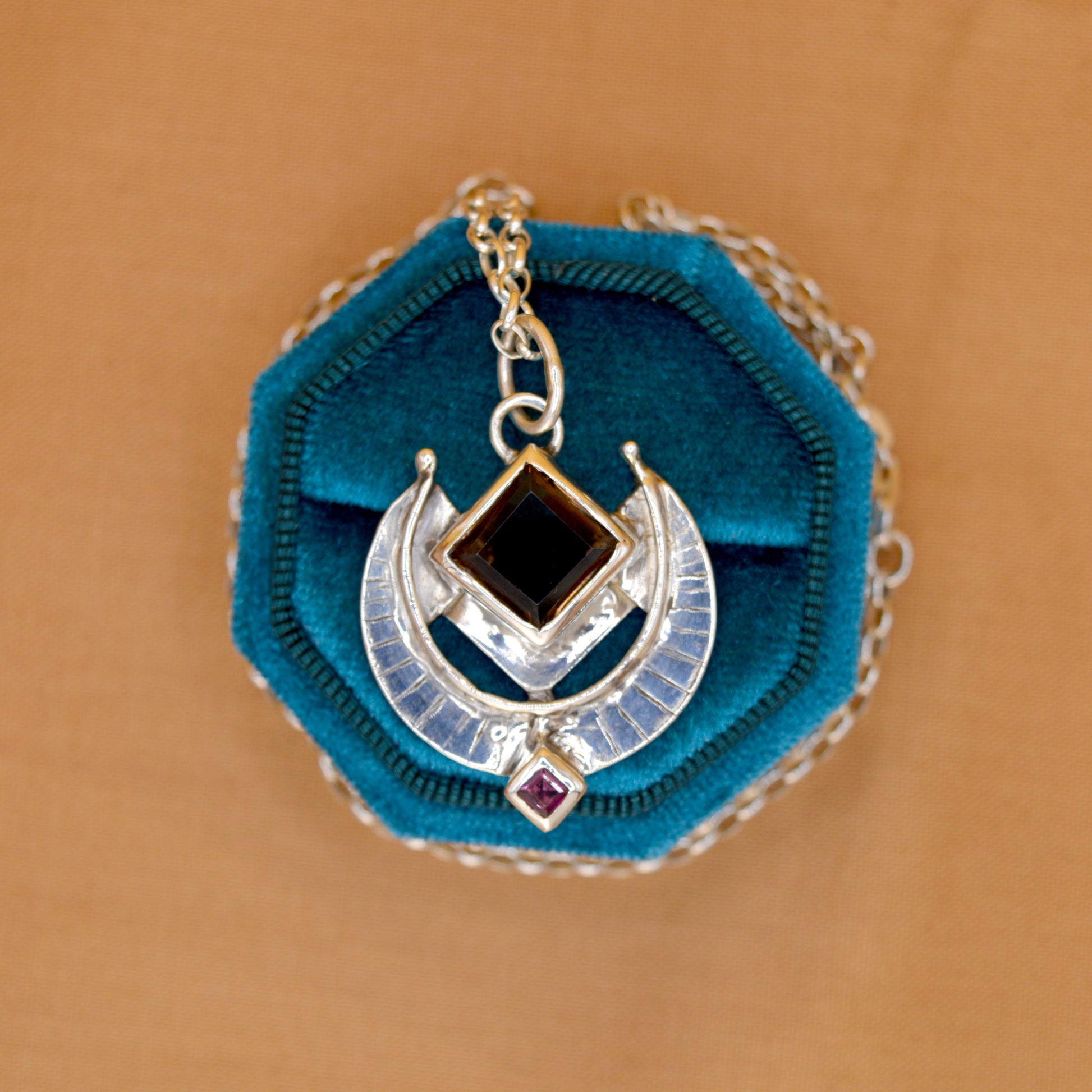 Necklace with blue pendant on a brown background