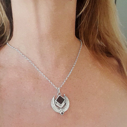 Silver necklace with a pendant on a person's neck