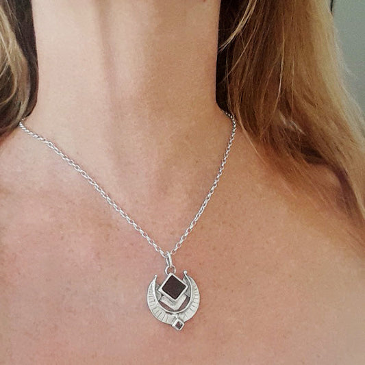 Silver necklace with a pendant on a person's neck