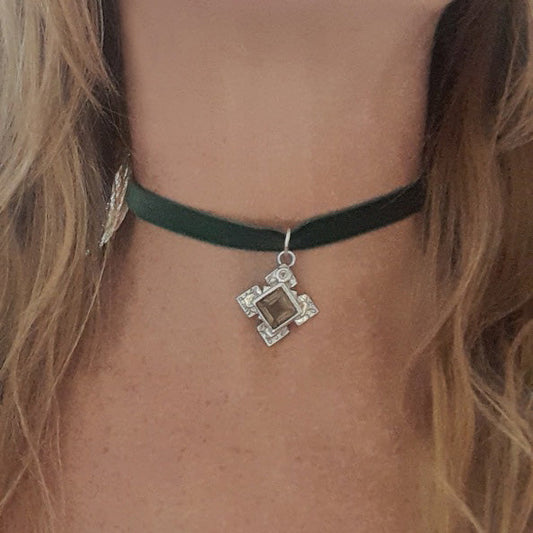 Green velvet choker with a square pendant on a person's neck