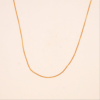 Gold necklace on a beige background