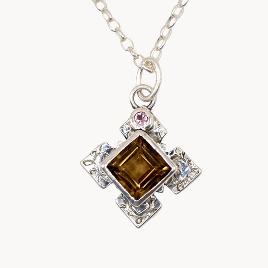 Silver necklace with a square brown gemstone pendant on a white background