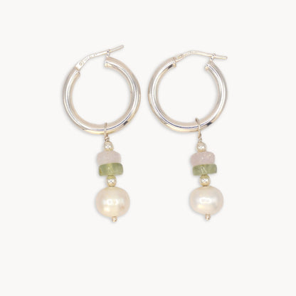 Silver hoop earrings with pearl and green bead drops on a white background