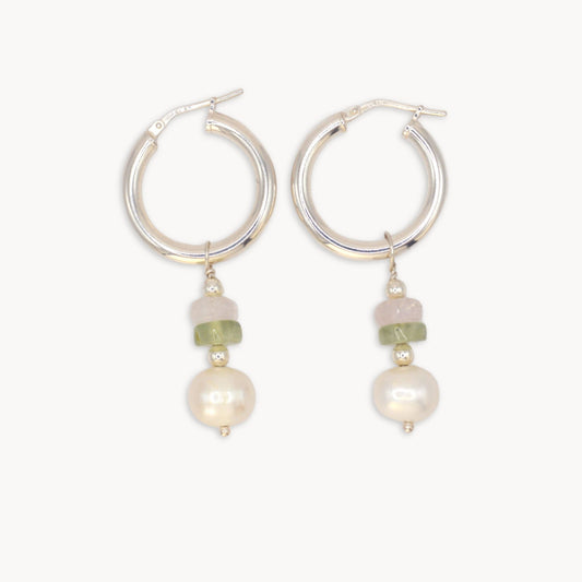 Silver hoop earrings with pearl and green bead drops on a white background